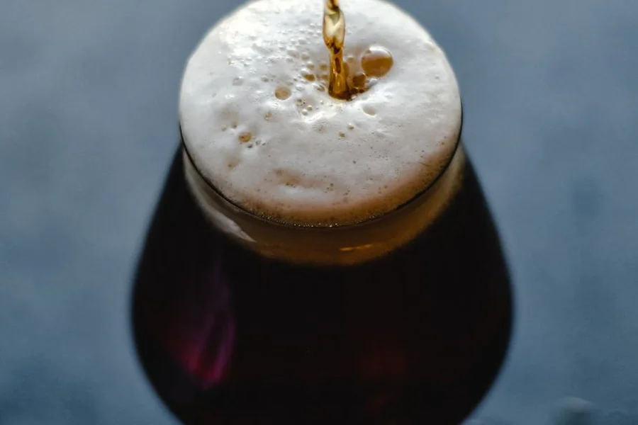 Pouring Coffee Stout Pouring dark coffee stout beer with rich creamy foam into a pint glass