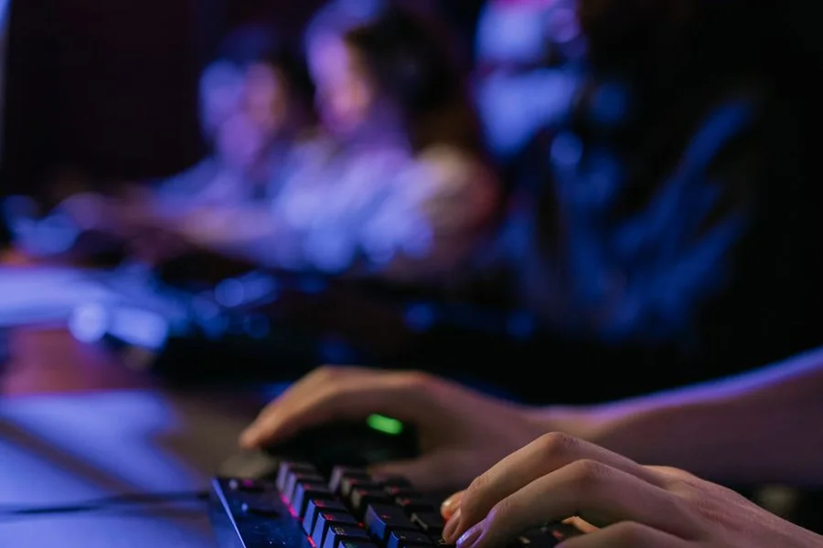 Gamer analyzing auto battler board positioning on computer screen with keyboard