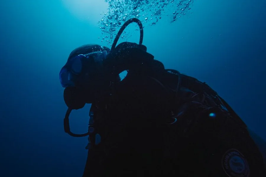 Diver Underwater Watch Gear Scuba diver checking underwater dive watch while swimming in clear ocean reef