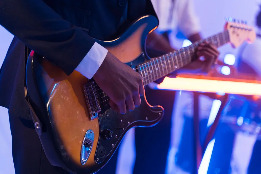 Electric Guitar Musician Performance Musician performing electric guitar solo on live stage under concert spotlights