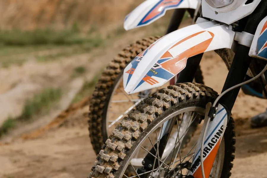 Motocross dirt bike motorcycle parked on an outdoor trail in a forest mountain setting