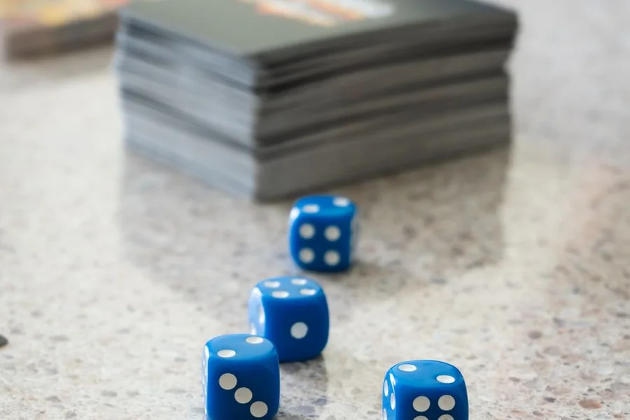 MTG Commander Tabletop Card Game Tabletop trading card game setup with cards, tokens, and multi-sided dice on wooden table