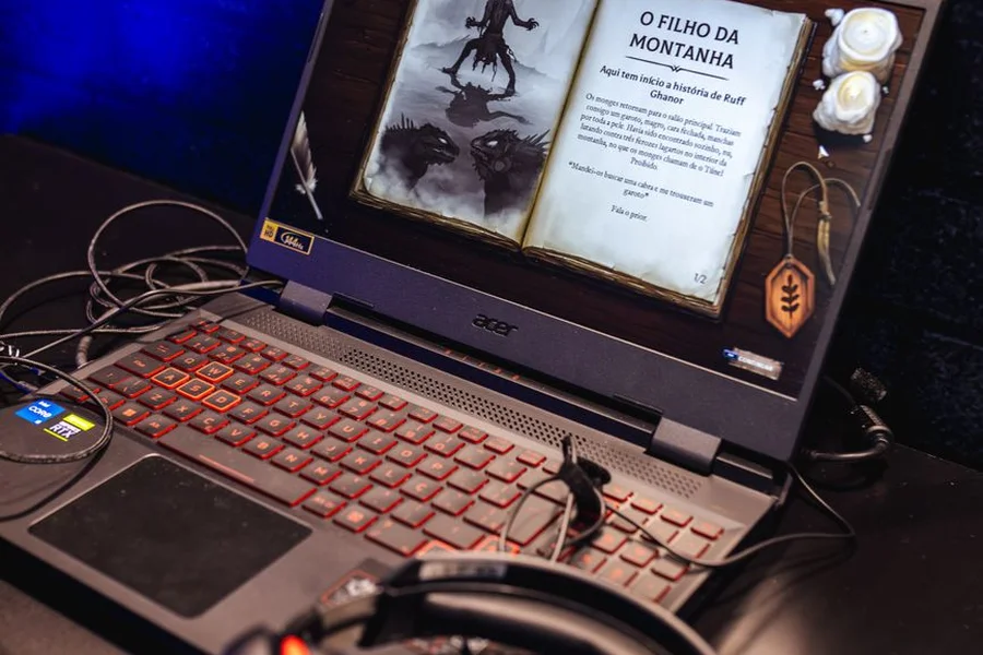 PC gaming desk setup with glowing keyboard and dual monitors displaying fantasy multiplayer roleplaying games