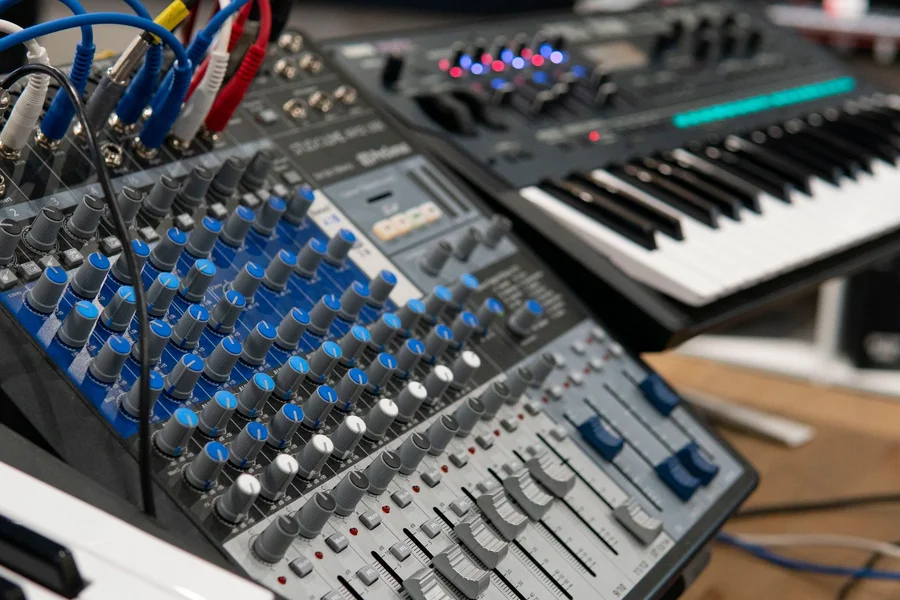 Close up of synthesizer keys and 5-pin DIN midi to usb lead connections in a recording studio